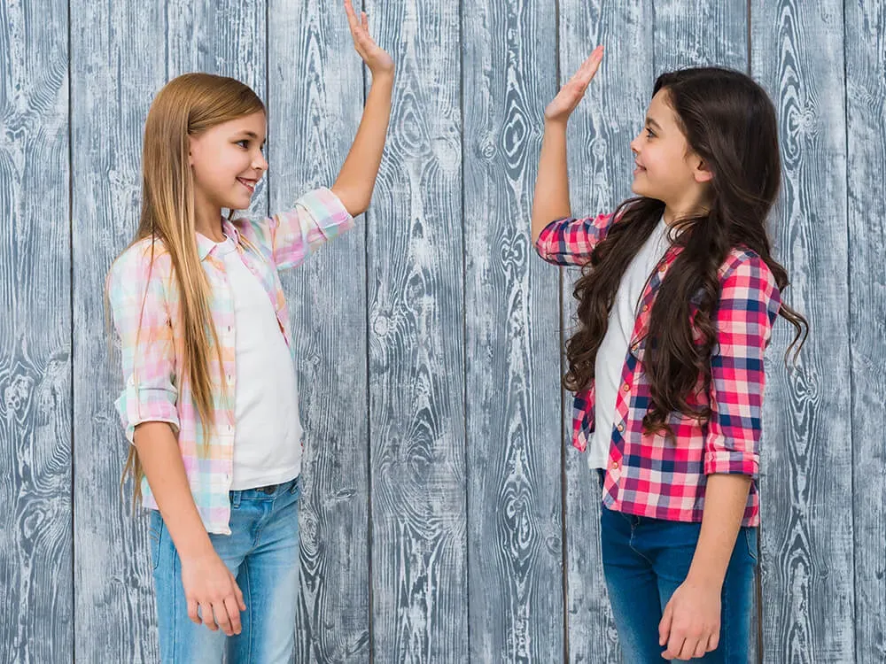 Children practicing friendship skills together on a playground