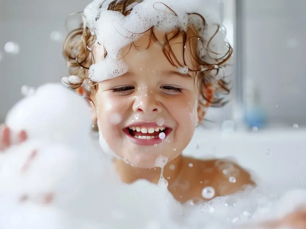 Child exploring sensory play with water and bubbles during bath time