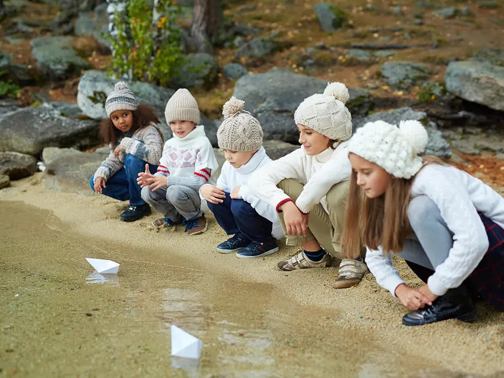 Educator documenting children's outdoor learning through observation notes and photography