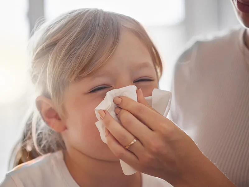 Some children might exhibit mild symptoms like a runny nose