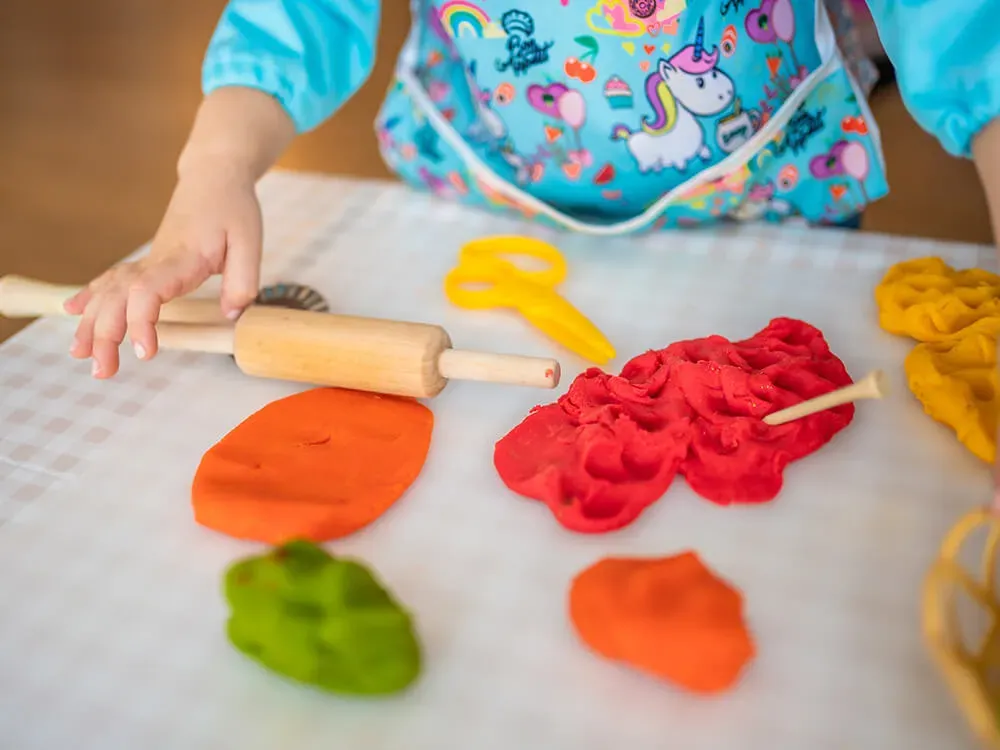 Children exploring scented playdough at a daycare sensory station