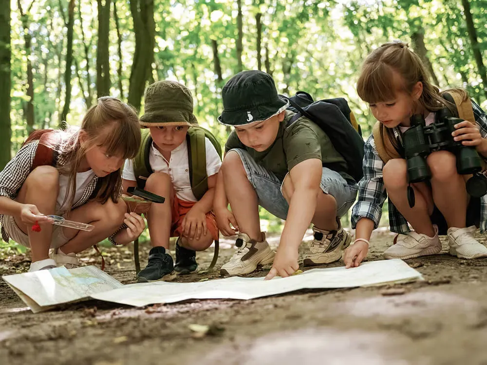 Children of different ages participating in summer camp activities together outdoors